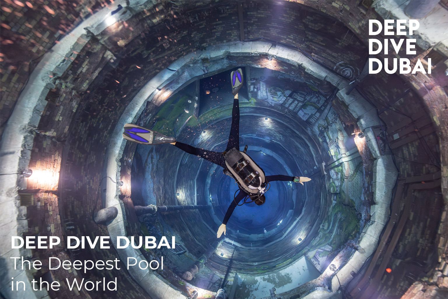 Person diving in a large pool with 'Deep Dive Dubai' branding.